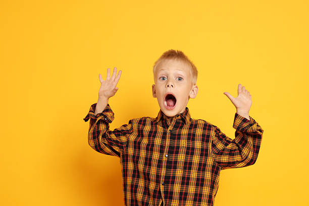 istock Scared little boy screaming on orange background. Space for text 2216480331
