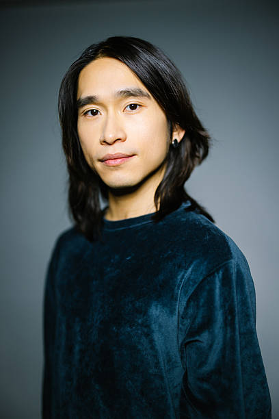 istock Mid adult Asian man looking at camera on gray backdrop 2216482361