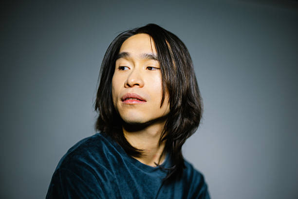istock Handsome Asian man in green shirt looking away in studio 2216482373