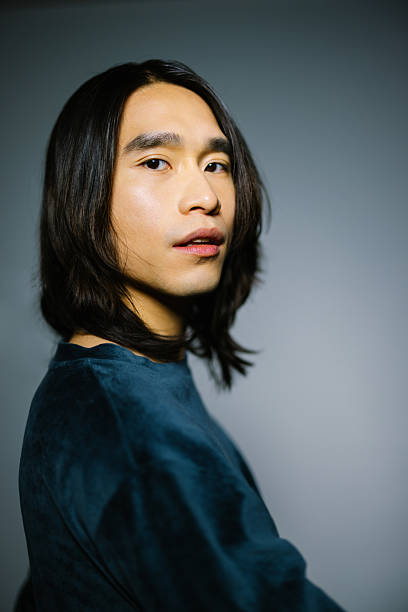 istock Handsome Asian man wearing green jumper on gray background 2216482386