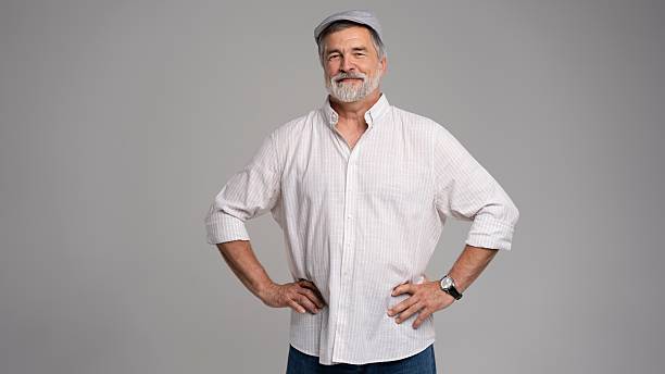 Friendly grey beard aged man in cap wear white shirt isolated on grey background