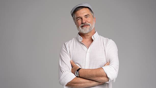istock Friendly grey beard aged man in cap wear white shirt isolated on grey 2216484285
