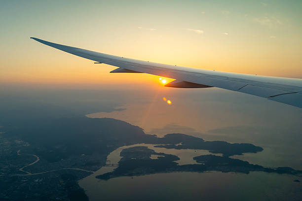 istock Airplane wing above Osaka coast during sunset descent flight 2216493792