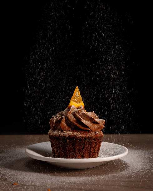 chocolate cupcake with orange and sprinkled sugar on a dark background