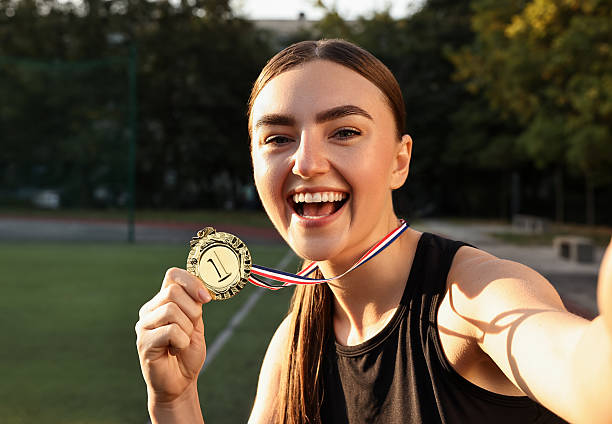 istock Happy winner with golden medal taking selfie at stadium 2216498183