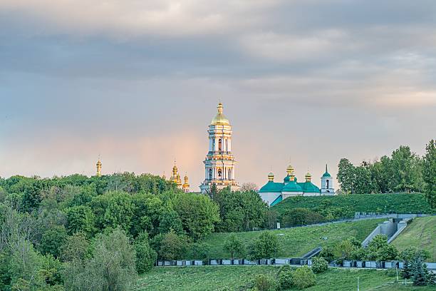 istock Russian Orthodox church complex, bell tower with multiple domes and cupolas, gold accents, green and red roofs, lush trees, natural setting, majestic, religious significance, soft lighting dawn or d 2216498339