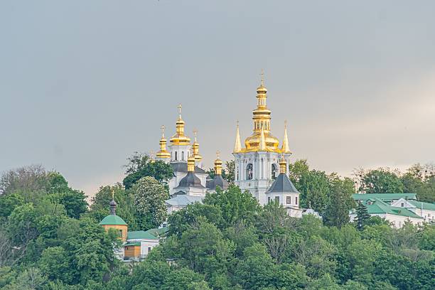 istock Large, grand religious building with multiple domes, central dome crowned with a cross, situated amidst lush greenery, warm lighting, man-made structures in the background, natural backdrop of trees, 2216499220