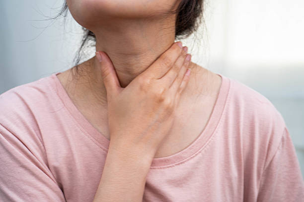 istock Asian woman touching her neck and throat for thyroid gland problem. 2216499664