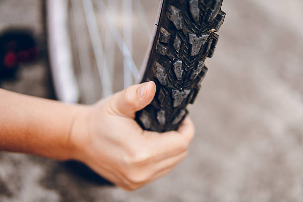 The woman is repairing the bicycle. Close up on hand.