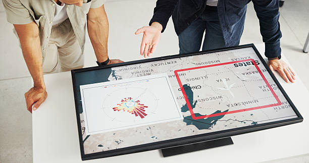 istock Engineer, energy and hands with map on screen for turbine location, power development and renewable innovation. Interactive display, above and people pointing to wind rose diagram for speed direction 2216502406