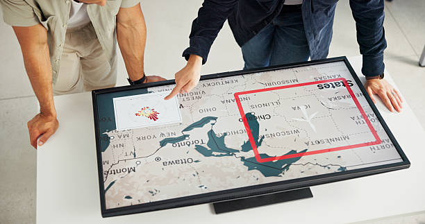 istock Engineer, people and hands with map on screen for turbine location, power development and renewable energy. Interactive display, above and employee pointing to wind rose diagram for speed direction 2216502457
