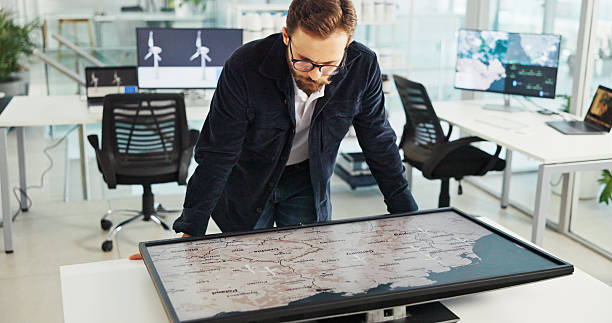 istock Business man, interactive display and map in office for sustainability, clean energy or wind turbine location. Global, world or worker with screen for planning project with renewable power specialist 2216502477
