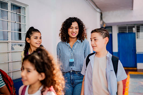 istock Teacher walking and talking to child students at school 2216508105