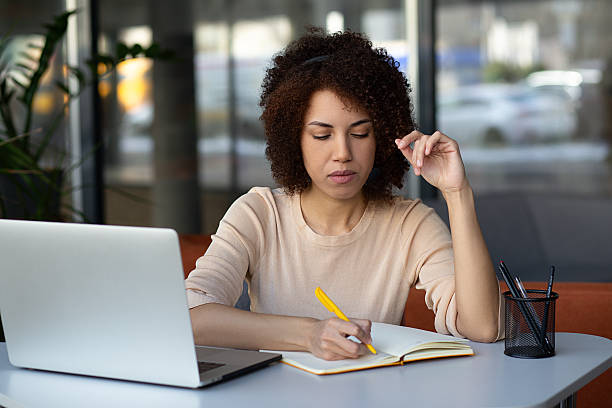istock Smiling multiracial woman with Afro hairstyle wearing headset using laptop computer for video connection, consults client online, working remotely from home office 2216509532