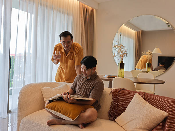 istock Creative Asian Chinese LGBTQ Couple Brainstorming with reference book at Home 2216511798