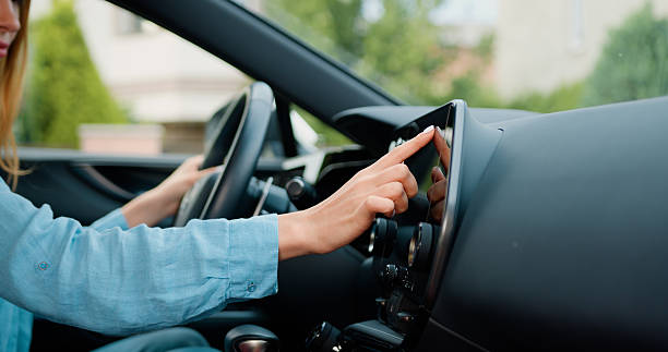 istock Side view of caucasian woman hand which typing needed coordinates on navigator touchscreen with modern assistance functions. Girl making scrolling and typing text on touch screen monitor on car. 2216515350