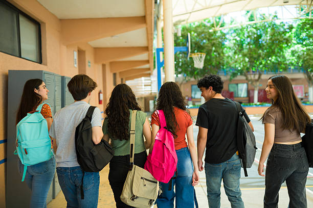 istock Rear view of a group of high school students walking down school hallway after class 2216516266