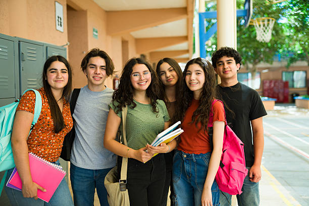 istock Latin high school students smiling at school hallway 2216516376