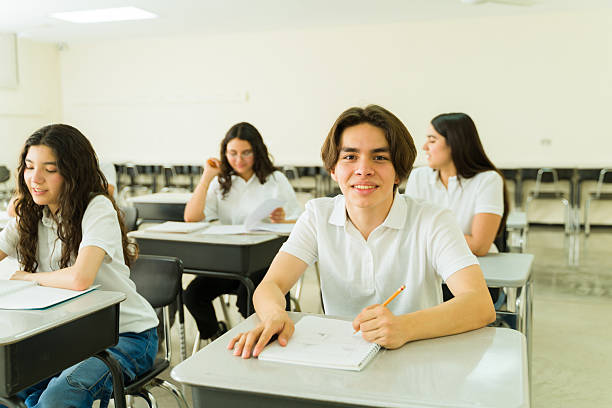 istock Portrait of happy high school student studying in classroom with classmates 2216517241