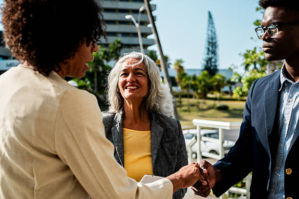 istock Coworkers talking and doing handshake outdoors 2216521123