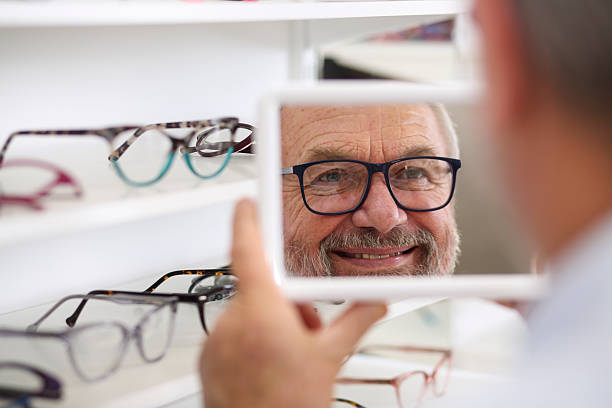 istock Senior Man Smiling While Trying on New Eyeglasses in Store 2216523511
