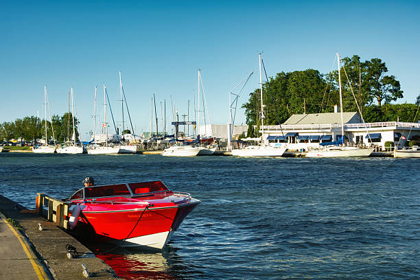 Man sits in motor boat at Port Dalhousie, St Catherines, Ontario on a sunny day.