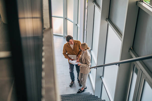 istock Business colleagues discussing documents on office stairs 2216524027