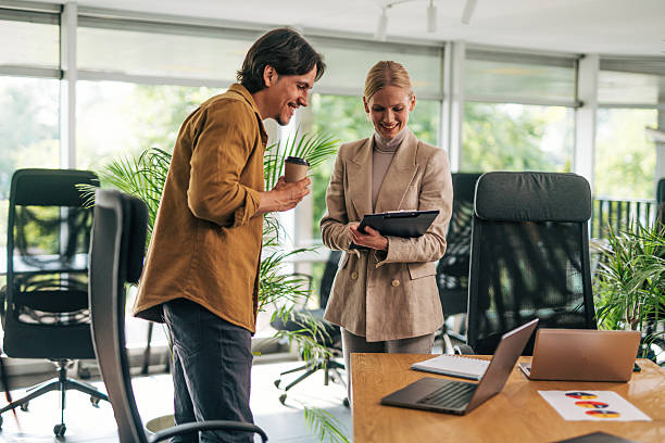 istock Smiling business colleagues discussing work in modern office 2216525187