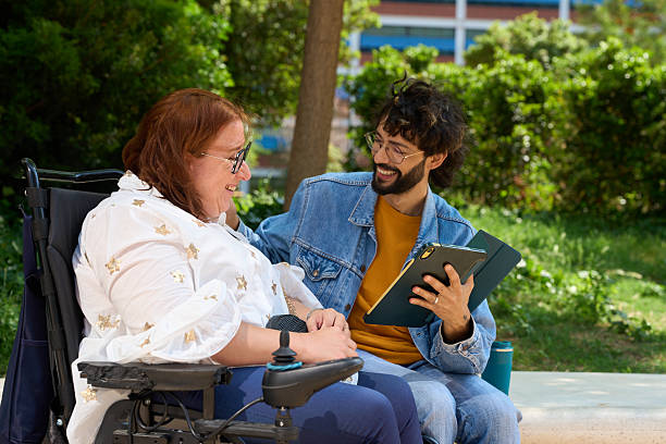 istock Smiling friends sharing a tablet in the park - wheelchair and disability concept 2216525607