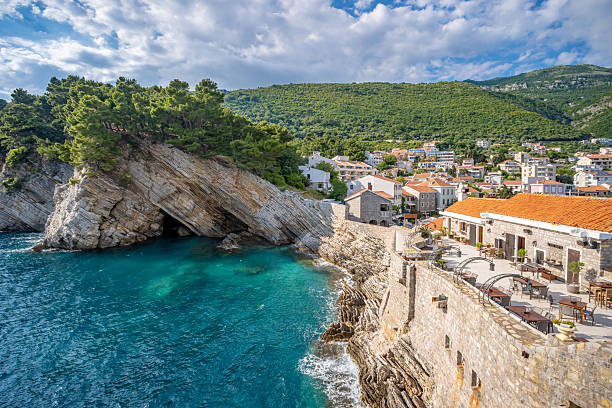 istock Petrovac  harbour wall with a cafe and town beyond in Montenegro 2216530482