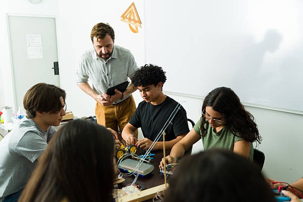 istock High school students building electronics project with teacher supervising 2216530997