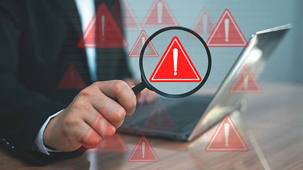 istock A businessman pointing at a red warning symbol on a digital screen. Cybersecurity alert or system error warning concept 2216532811
