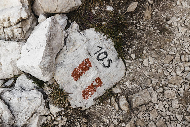 Close-up of a trail marker painted on a rock, indicating hiking route number 105 in the Dolomites, Italy. A common way to guide trekkers through the rugged alpine paths.
