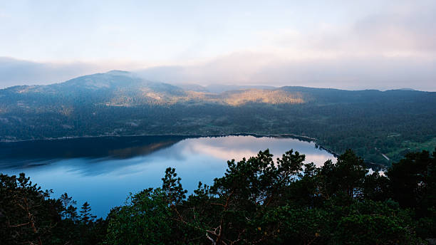 istock Majestic view over tranquil lake reflecting mountains in Norway at dawn 2216536582