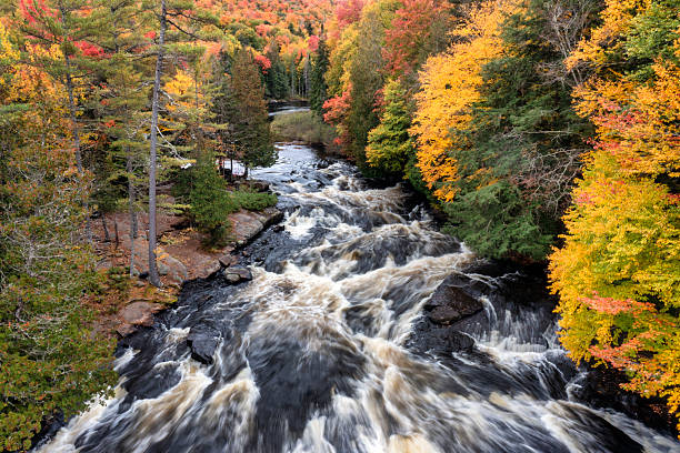 Bracebridge Falls runs into Muskoka River with Trans Canada Trail and autumn foliage colors in Ontario, Canada