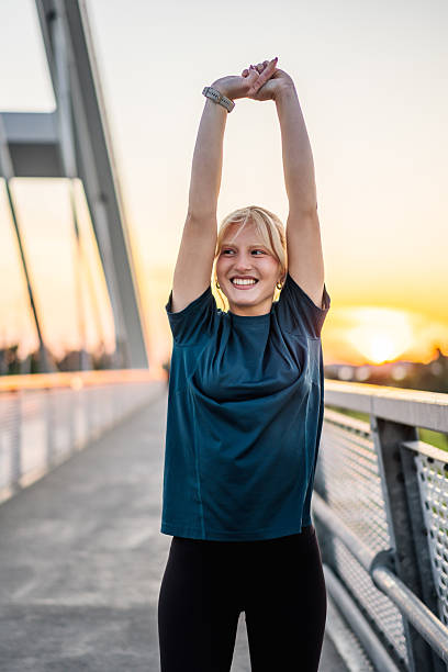 istock Young sporty woman stretching on a bridge at sunset 2216538121