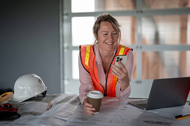 istock Female Architect at Work Reviewing Plans and Communicating with Team 2216540216