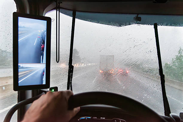 istock Interior truck view with windshield covered by intense rain, road visibility reduced, and wipers struggling against the storm.Stormy day on the road 2216542954