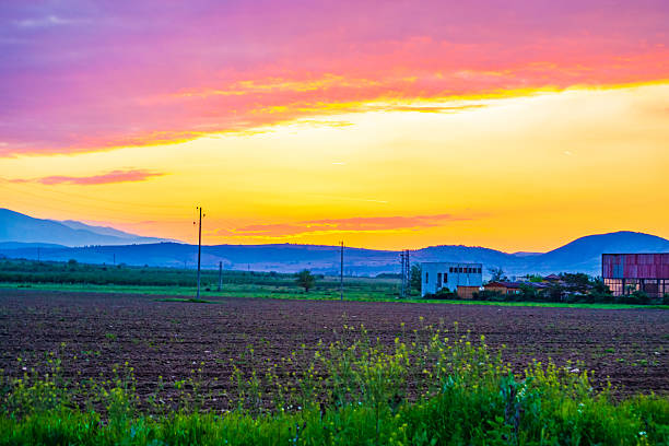 Dramatic colorful sunset skies ,plowed field in Vacha river valley on the foreground,Rhodope mountains in the distance,Krichim town ,Plovdiv region,Bulgaria