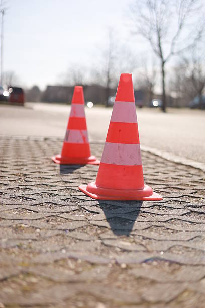 istock Two orange and white traffic cones are on the ground 2216545272