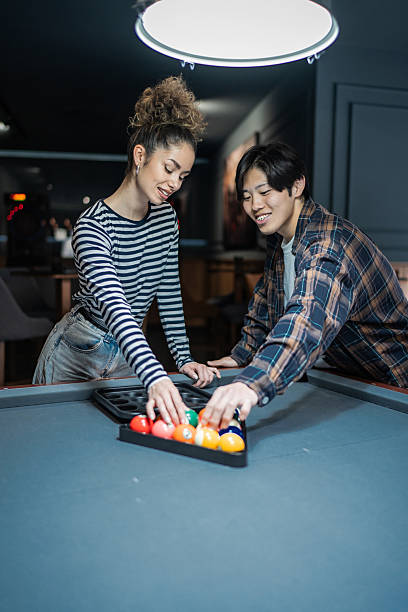 Young couple setting up billiard balls for a game of pool