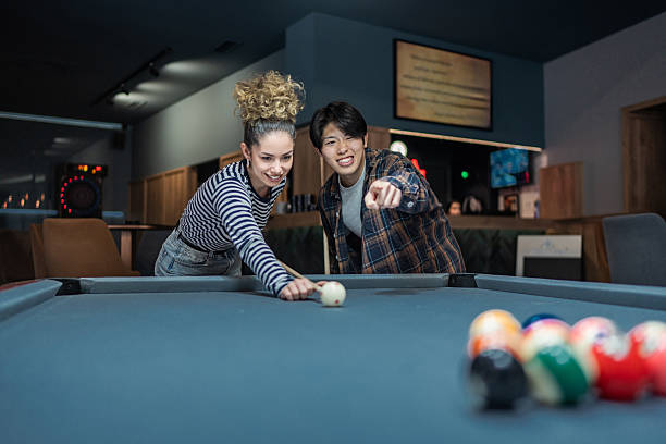 istock Young couple playing billiards and having fun in a pub 2216552543