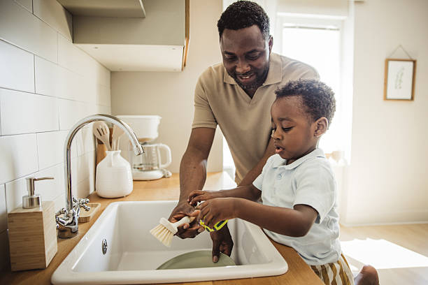 istock Father and son washing dishes at home 2216552826
