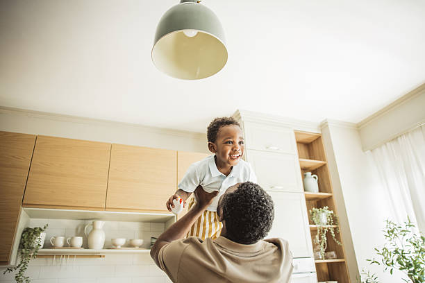 Playful father lifting newborn baby