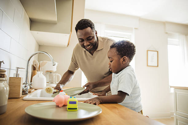 istock Father and son washing dishes at home 2216552873