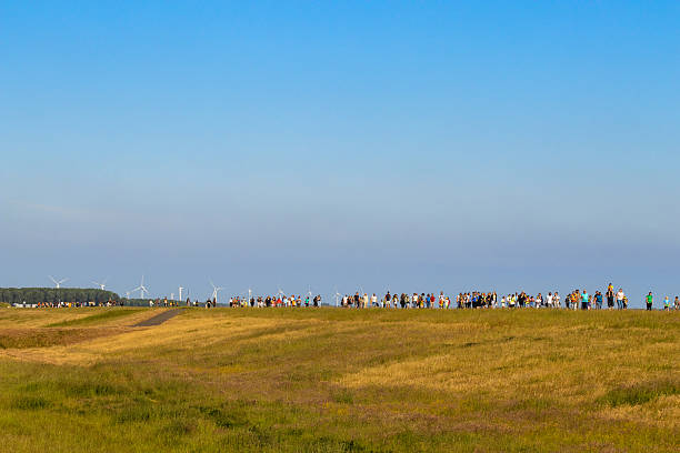 The Avondvierdaagse is an annual walking event in the Netherlands, where participants walk for four evenings. It is a popular activity, especially for children, but also for adults, and is often organized by schools or local organizations. On May 20, a group of parents, children and teachers walk along the Gooimeerdijk along the Gooimeer, 20 mei, Gooimeerdijk, Almere Haven, Flevoland, The Netherlands
