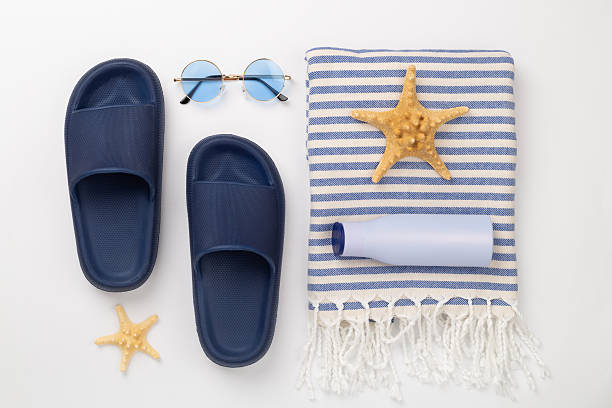 istock Beach towel with summer accessories on color background, top view 2216566064