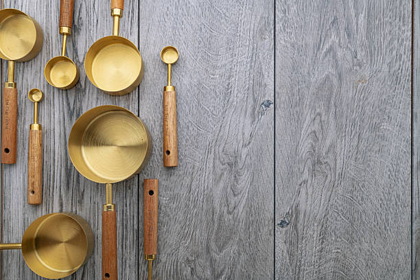 istock Copper measuring cups with wooden handles on gray kitchen table. View from above. Space for text. 2216567294