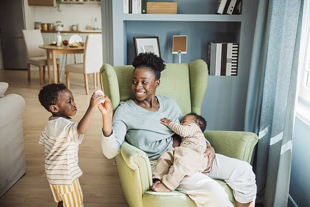 istock Young mother breastfeeding baby while playing with toddler 2216567349