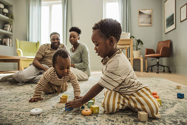 Young family playing together with wooden toys at home.